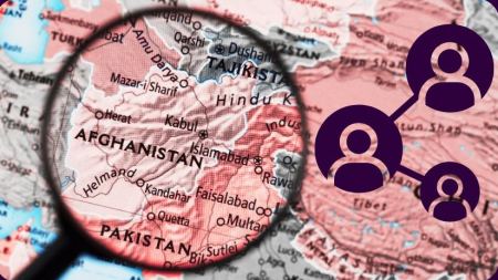 Eine Lupe ist auf einer Landkarte auf das Land Afghanistan gerichtet. Am Bildrand befinden sich lilafarbene Kreise, in denen sich Figurensymbole befinden. Die Kreise sind mit Linien verbunden. 