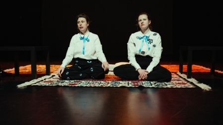 Zwei Frauen sitzen auf dem Boden und gucken sehr ernst