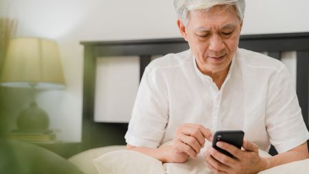 Senior schaut auf Smartphone Senior schaut auf Smartphone