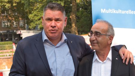 Zwei Männer in Anzügen stehen dicht beieinander