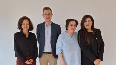 Das Team des Bildungswerk Multi Kulti, drei Frauen und ein Mann, lächeln in die Kamera.