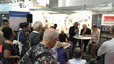 Standgespräch türkeibezogene Konflikte Menschen vor Stand auf der Buchmesse