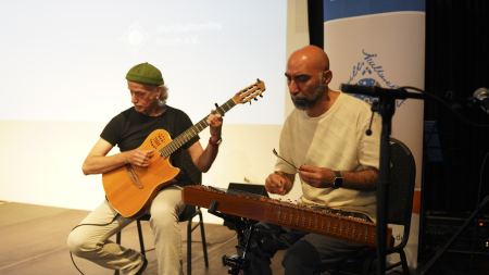 Zwei Musiker spielen sitzend auf der Bühne.