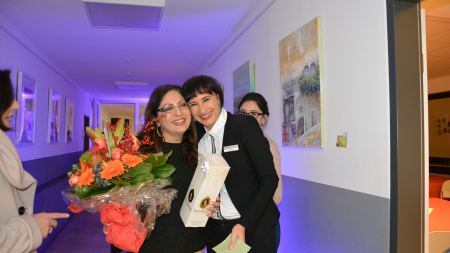 Mitarbeiterinnen mit Blumenstrauß in der Hand