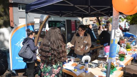Am Infostand verkauft eine Mitarbeiterin Waffeln