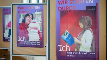 Drei Plakate mit abgebildeten Frauen hängen an Stellwänden.