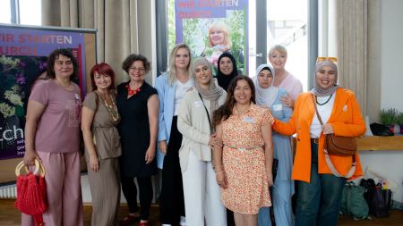 Gruppenfoto mit zahlreichen Frauen, die in die Kamera lächeln.