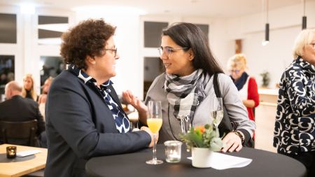 2 Frauen unterhalten sich am Stehtisch