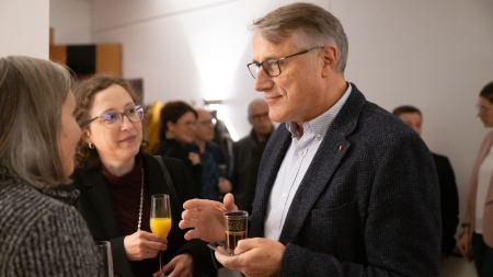 1 Mann und zwei Frauen stehen im Gesprächskreis