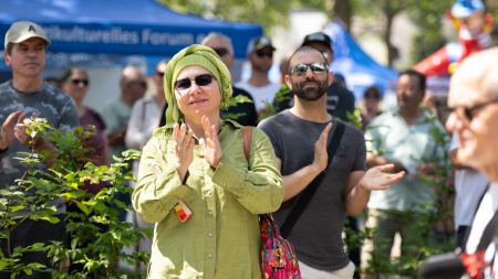 Eine Frau und ein Mann mit Sonnenbrille klatschen in die Hände.