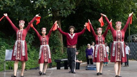 Auf einer Bühne stehen fünf Personen in traditionellen Gewändern.