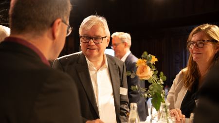 drei Personen im Gespräch am Stehtisch