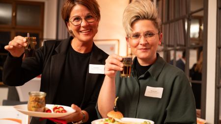 Zwei Frauen mit Esstellern in der Hand