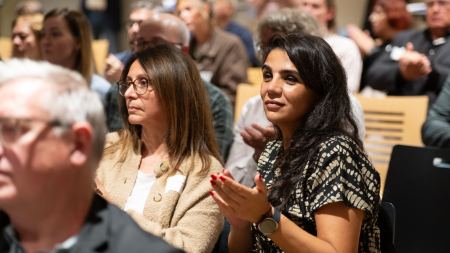Zwei Frauen sitzen im Publikum und applaudieren.