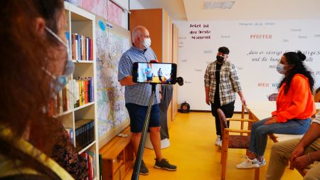 Jugendliche im Interview mit Herrn Berger, aufgenommen mit Kamera und Smartphone