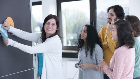 Fünf Menschen vor Pinnwand in Workshop-Situation