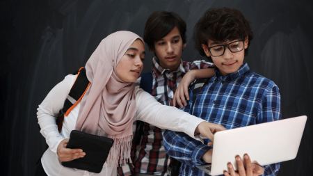 Drei Schüler*innen arbeiten gemeinsam am Laptop
