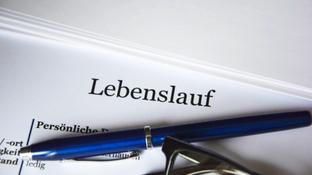 Blatt Papier, auf dem der Titel "Lebenslauf" steht. Darauf liegt ein Kugelschreiber