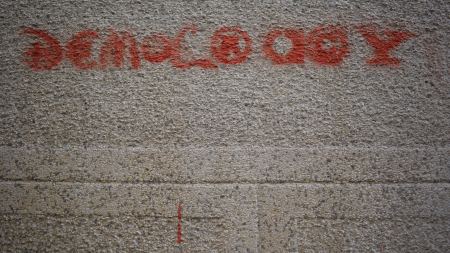 graue Wand, auf die "Democracy" gesprüht wurde graue Wand, auf die "Democracy" gesprüht wurde