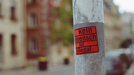 Sticker "Kein Mensch ist illegal" an Straßenlaterne