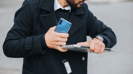 Mann mit Laptop schaut auf Uhr