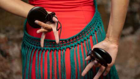traditionell gekleideter Mensch mit schwarzen Kastagnetten in der Hand