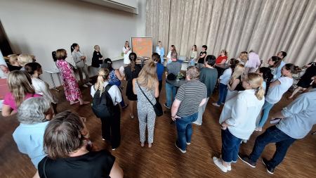 Rückenansicht einer größeren Gruppe von Menschen, die auf eine Stellwand blicken.
