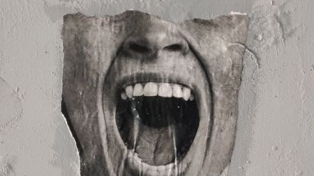 Graffito eines augenlosen Gesichts mit aufgerissenem Mund auf einer Wand