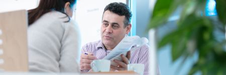 Beratung Mann berät Frau mit Dokument und Stift in der Hand