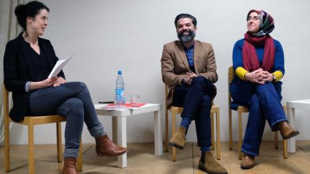 Filmvorführung und Diskussion „Gott existiert, ihr Name ist Petrunya" Moderatorin eines Podiums im Gespräch mit einem Mann und einer Frau