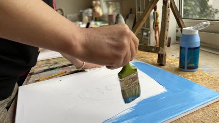 Kunstworkshop Frauenwoche Hamm Weiße Leinwand wird mit Pinsel blau grundiert