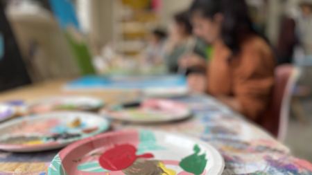 Kunstworkshop Frauenwoche Hamm Pappteller mit verschiedenen Acrylfarben, im Hintergrund Atelier