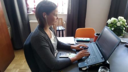 Frau arbeitet mit Headset und Laptop im Home Office