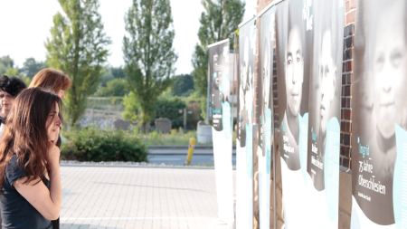 Ausstellung "Gesicht einer Flucht" verschiedene Personen betrachten Ausstellung "Gesicht einer Flucht" beim Multi-Kulti-Preis 2017