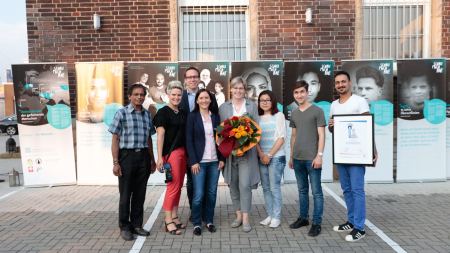 Sonderpreisträgerin des Multi-Kulti-Preises 2017, Gerburgis Sommer, mit Mitstreiter*innen vor ihrer Ausstellung "Gesicht einer Flucht"