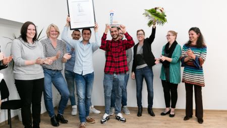 Preisträger 2016: Projekt Ankommen e.V. Preisträger des Multi-Kulti-Preises 2016, Projekt Ankommen, mit Urkunde, Pokal und Blumen
