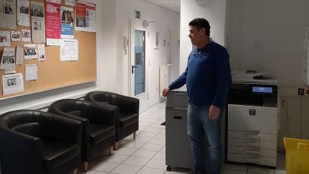 Mann zeigt leeren Wartebereich mit Sesseln