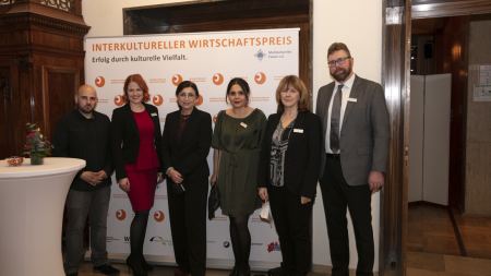 Gruppenbild von sechs Personen vor Banner "Interkultureller Wirtschaftspreis"