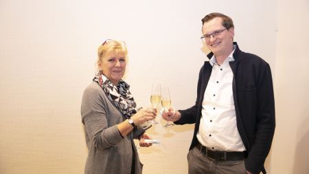 Frau und Mann stoßen mit Sekt an