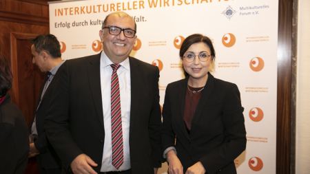 Mann und Frau vor Fotowand "Interkultureller Wirtschaftspreis"