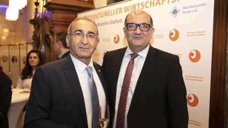 Zwei Männer vor Fotowand "Interkultureller Wirtschaftspreis"