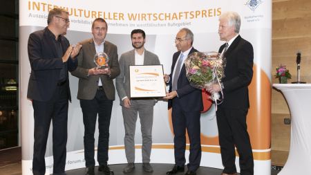 Gruppenbild mit fünf Männern mit Preispokal und -urkunde