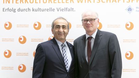 Kenan Küçük mit IWP-Gast vor IWP-Wand Kenan Küçük mit IWP-Gast vor IWP-Wand