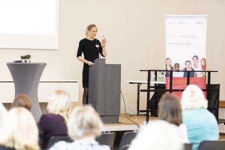 Dr. Anne Wilde hält eine Rede auf der Bühne hinter einem Rednerpult