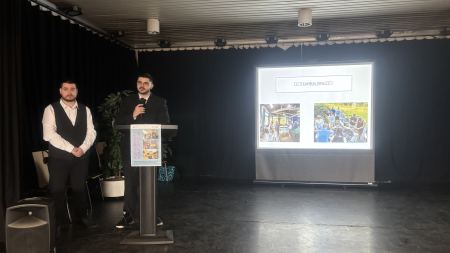 Projektteilnehmer auf der Bühne kommentieren die Fotos auf dem Bildschirm