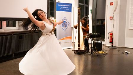 Janan Almasi beeindruckt mit persischem Tanz, im Hintergrund begleitet durch die Harfenistin Zainab Lax