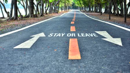 Straße mit zwei entgegengesetzten Fahrstreifen, in der Mitte steht "Stay or Leave"