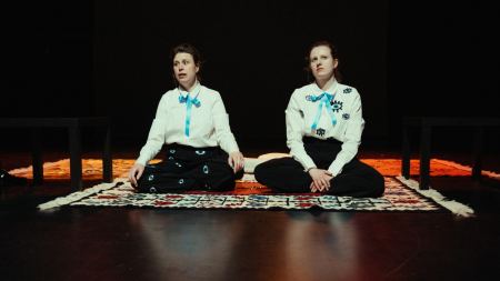 Zwei Frauen sitzen auf dem Boden und gucken sehr ernst