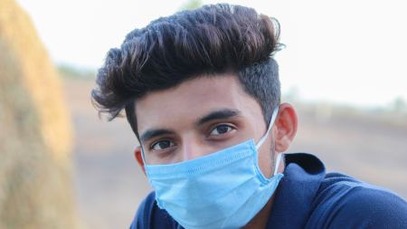 Junger Mann mit Mund-Nasenschutz
