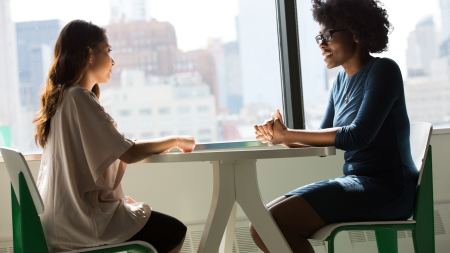 zwei Frauen sitzen sich gegenüber und reden